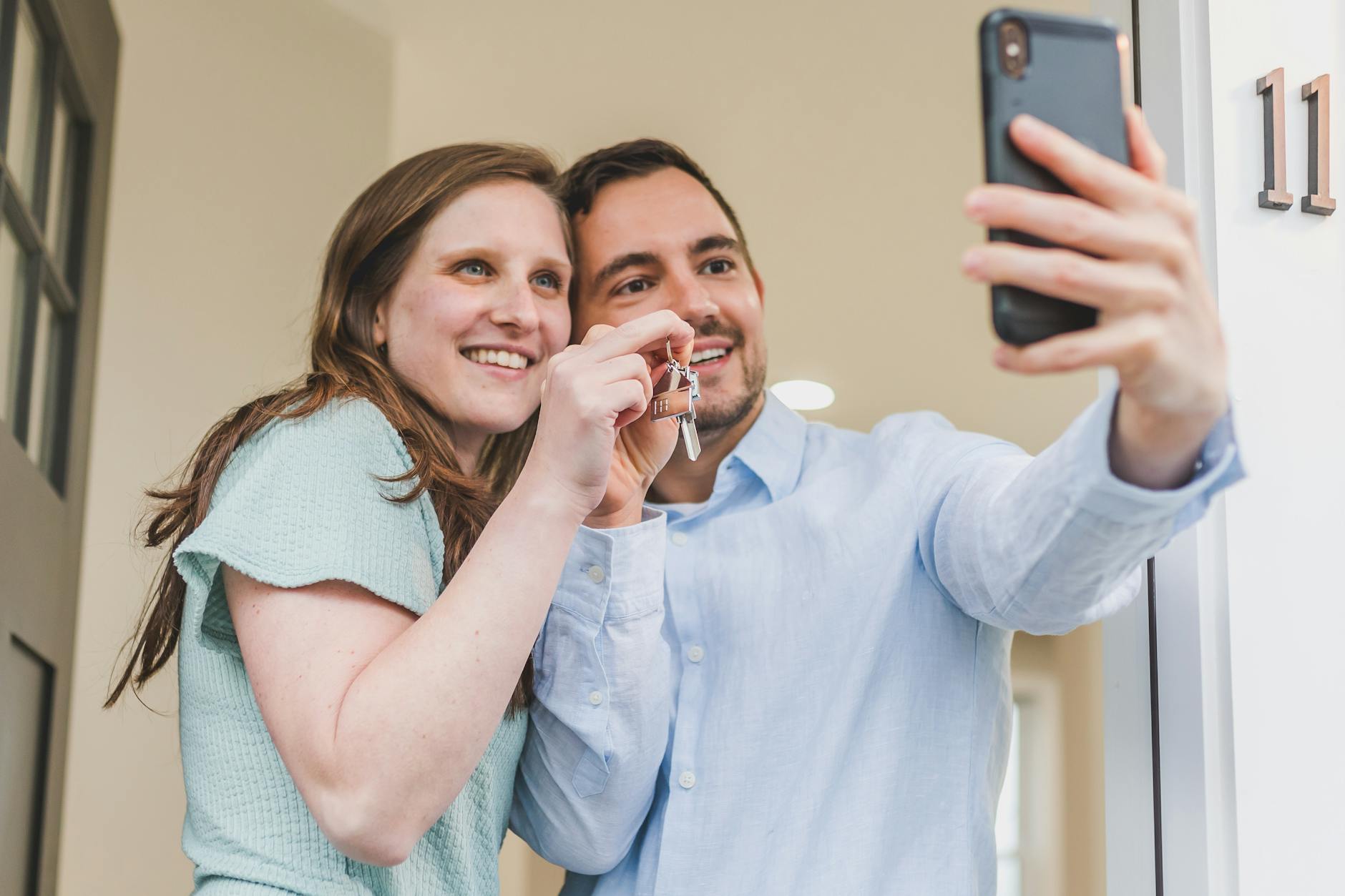 a couple taking a selfie with their new home key